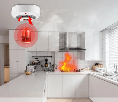 Brandlarm reagerar på köksbrand, rök och lågor vid spisen i modernt kök